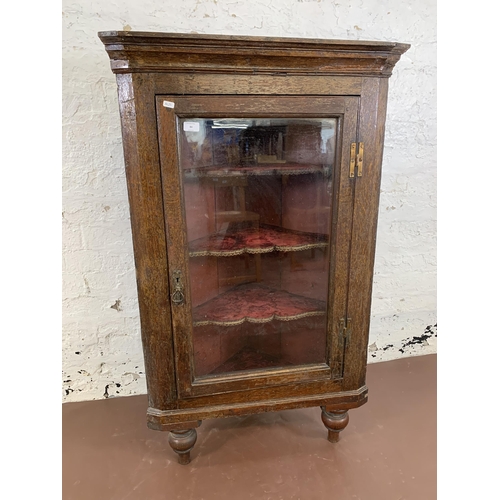 84 - A George III oak corner cabinet with brass H hinges and later added mahogany supports