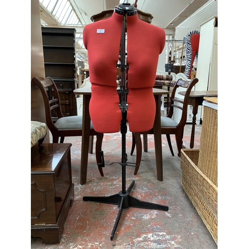 89 - A red fabric and black plastic adjustable dressmaker's mannequin