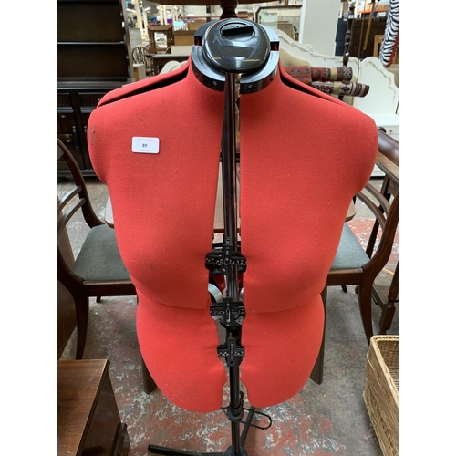 89 - A red fabric and black plastic adjustable dressmaker's mannequin