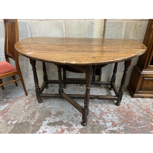 5 - A Georgian oak drop leaf gate leg dining table - approx. 74cm high x 128cm wide x 134cm long