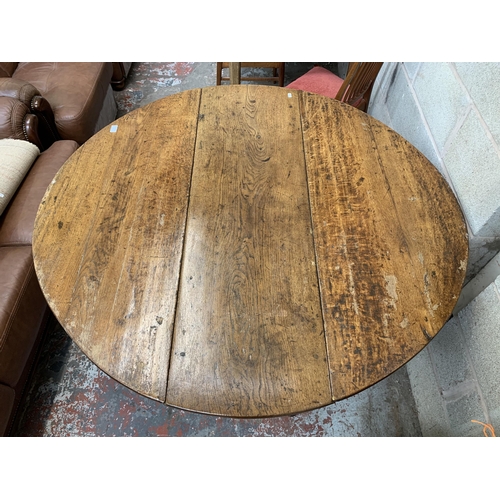 5 - A Georgian oak drop leaf gate leg dining table - approx. 74cm high x 128cm wide x 134cm long