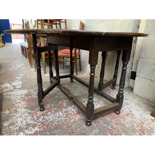 5 - A Georgian oak drop leaf gate leg dining table - approx. 74cm high x 128cm wide x 134cm long