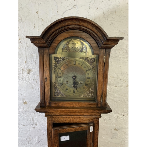 6 - A Georgian style oak cased grandmother clock with brass 'Tempus Fugit' face, key and pendulum - appr... 