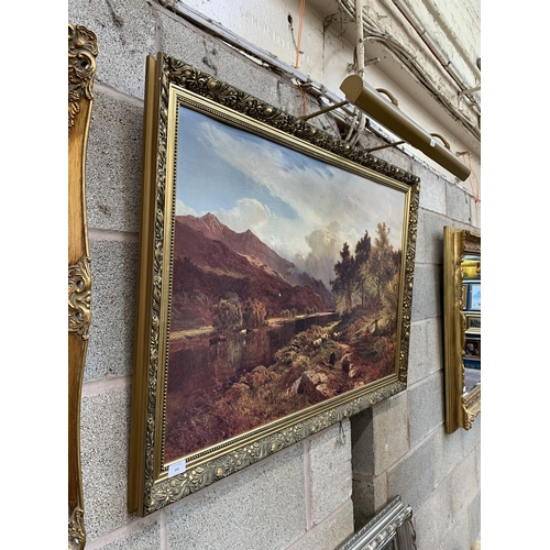 252 - A gilt framed landscape scene print with picture light - approx. 71cm high x 110cm wide