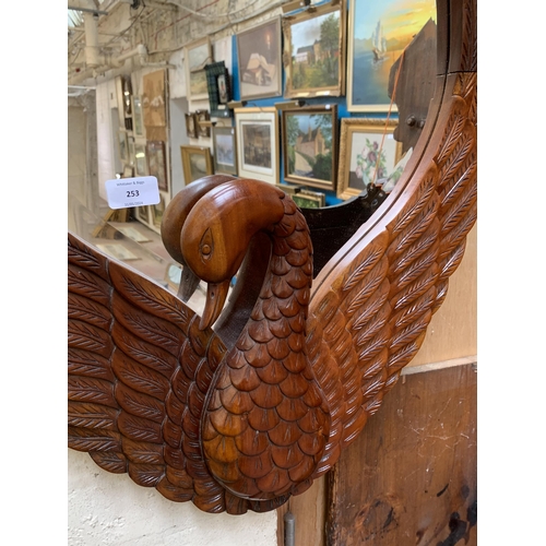 253 - A carved mahogany swan framed bevelled edge wall mirror - approx. 78cm high x 56cm wide