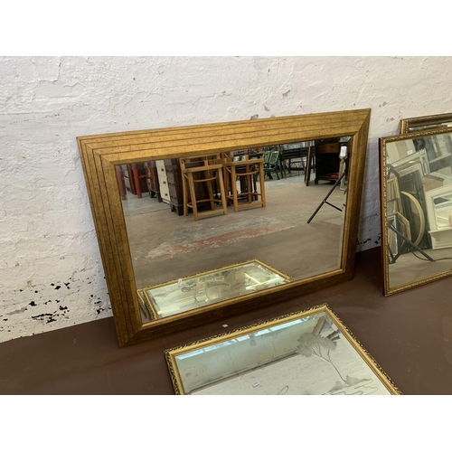 305 - Four gilt framed wall mirrors - largest approx. 109cm high x 78cm wide