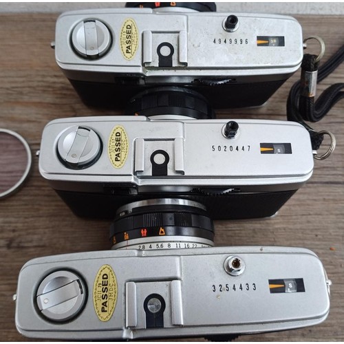 644 - Four Olympus compact 35mm cameras, three Trip 35 and one XA2 fitted with A11 flash