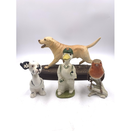 324 - Four ceramic figurines, Beswick The Labrador, Goebel Robin, Beswick Puppit Dalmatian and Acorn 'Out ... 