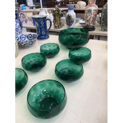 383 - Seven green glass bowls - largest approx. 20cm diameter