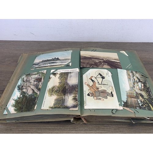 553 - An early 20th century postcard album containing a collection of antique and later postcards to inclu... 