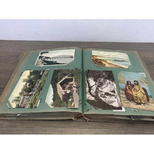 553 - An early 20th century postcard album containing a collection of antique and later postcards to inclu... 