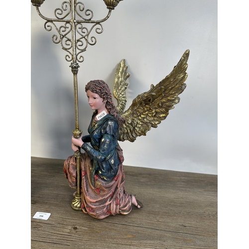 556 - A pair of contemporary angel three branch candelabras - largest approx. 68cm high