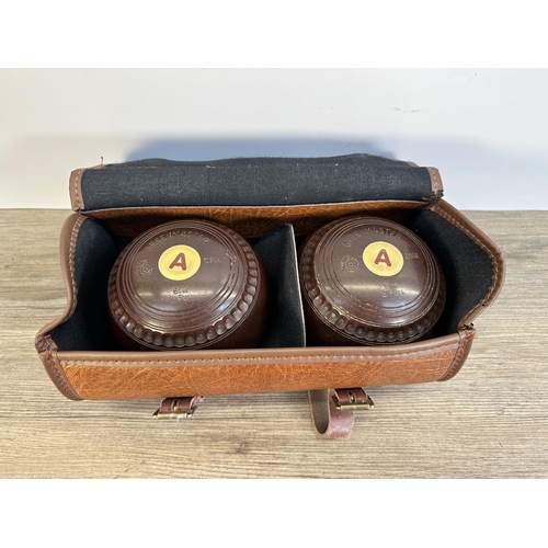 563 - A pair of brown leather cased Greenmaster G506 2 crown green bowls