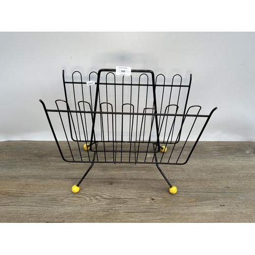 568 - A mid 20th century black metal atomic two section magazine rack - approx. 33cm high x 39cm long