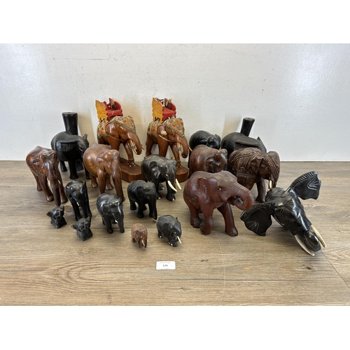 579 - A collection of carved wooden elephants to include ebony, teak etc.