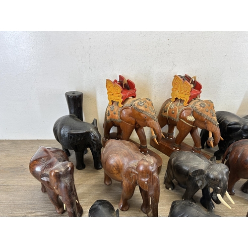 579 - A collection of carved wooden elephants to include ebony, teak etc.