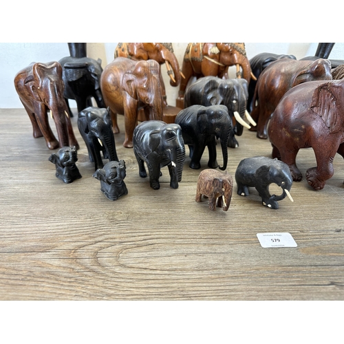 579 - A collection of carved wooden elephants to include ebony, teak etc.