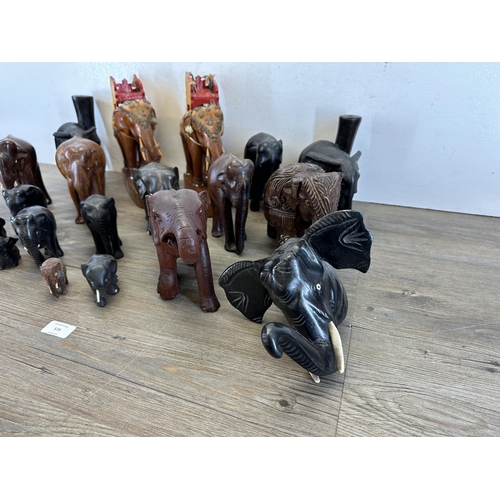 579 - A collection of carved wooden elephants to include ebony, teak etc.