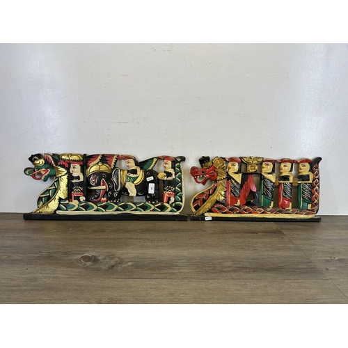 588 - A pair of Balinese carved wooden and hand painted wall panels - largest approx. 61cm long x 25cm hig... 