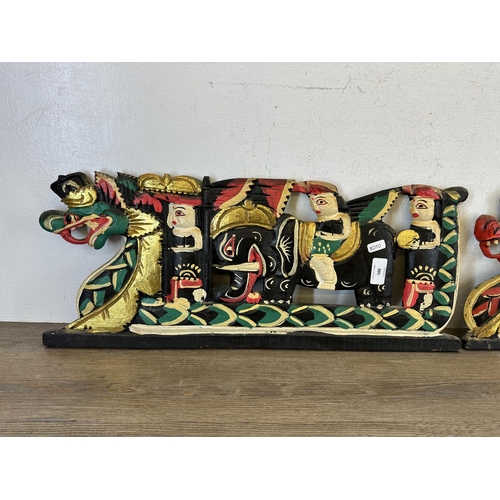 588 - A pair of Balinese carved wooden and hand painted wall panels - largest approx. 61cm long x 25cm hig... 