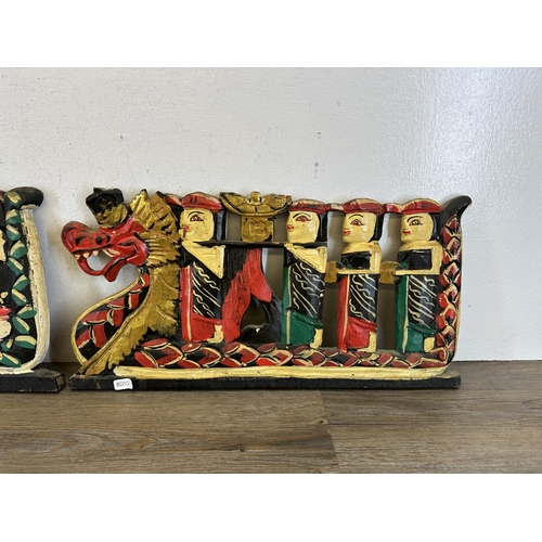 588 - A pair of Balinese carved wooden and hand painted wall panels - largest approx. 61cm long x 25cm hig... 