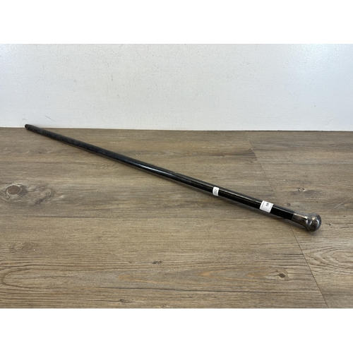 599 - A late 19th/early 20th century ebonized walking cane with hallmarked London silver top - approx. 90c... 