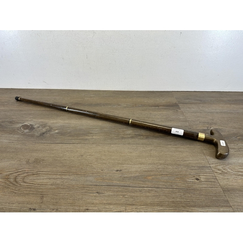 602 - A novelty brass and hardwood golf putter handle walking stick - approx. 87cm long