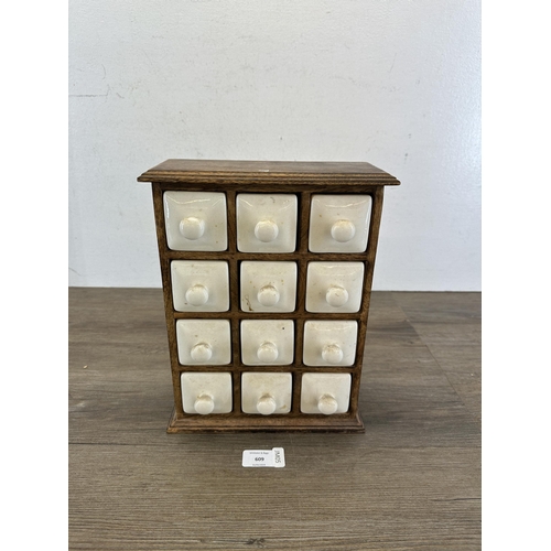 609 - A 19th century style hardwood spice cabinet with twelve ceramic drawers - approx. 29.5cm high x 23cm... 