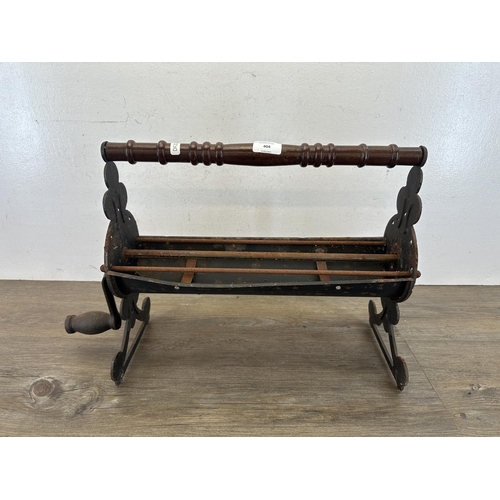 404 - A 19th century style cast metal newspaper log roller - approx. 36cm high x 43cm wide