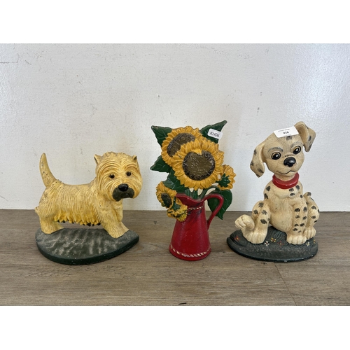 418 - Three vintage cast iron and painted doorstops, two dogs and one sunflower - largest approx. 27cm hig... 