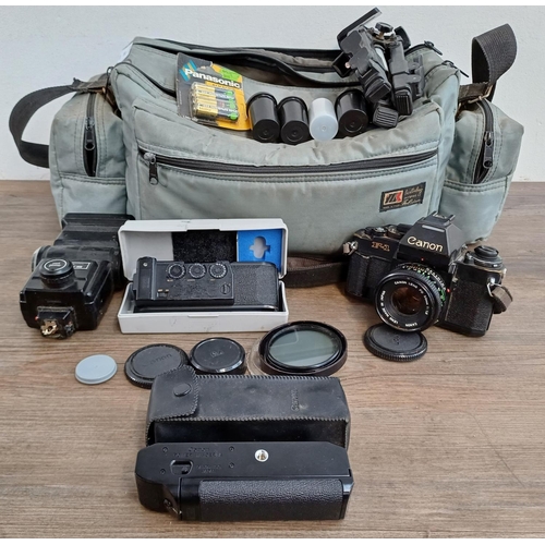 679 - A camera bag containing Canon 'New' F-1 35mm SLR camera fitted with Canon FD 1:1.8 50mm lens, cased ... 