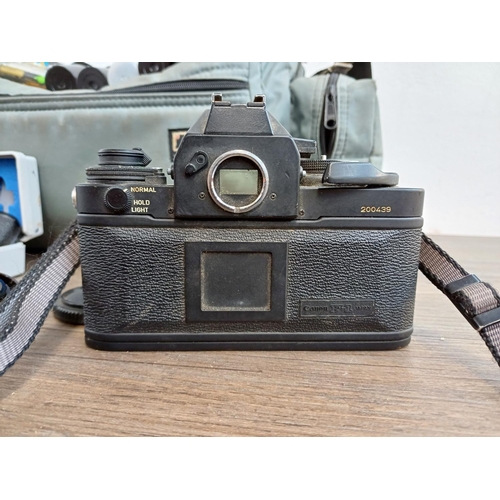 679 - A camera bag containing Canon 'New' F-1 35mm SLR camera fitted with Canon FD 1:1.8 50mm lens, cased ... 