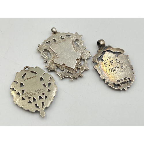 2067 - Three watch fobs/medallions, two hallmarked Birmingham silver and one white metal - approx. gross we... 