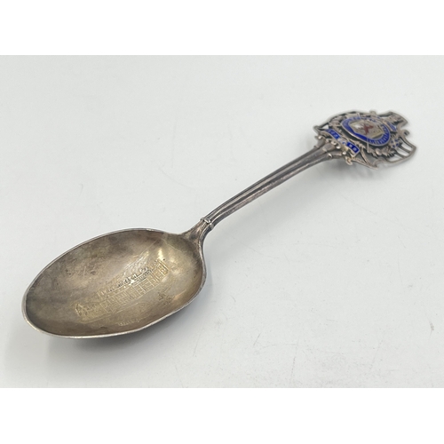 2102 - Three pieces of sterling silver, one Holyrood Palace enamel decorated commemorative spoon, one napki... 