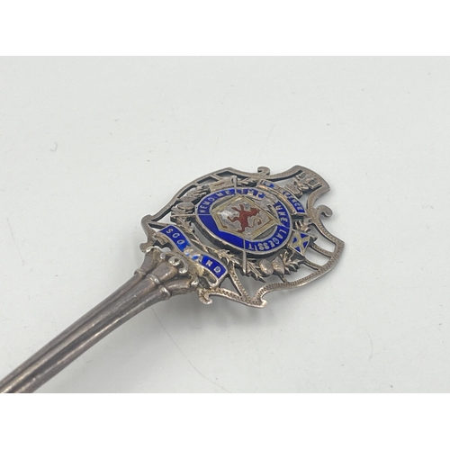 2102 - Three pieces of sterling silver, one Holyrood Palace enamel decorated commemorative spoon, one napki... 