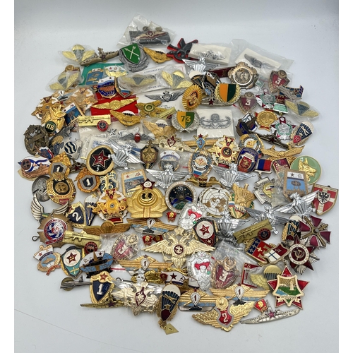 2159 - A large collection of military badges to include Russian, US Air Force wings etc.