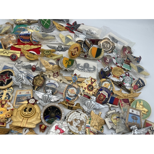 2159 - A large collection of military badges to include Russian, US Air Force wings etc.