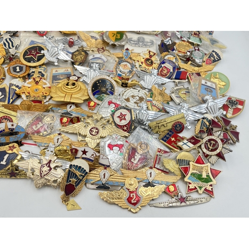 2159 - A large collection of military badges to include Russian, US Air Force wings etc.