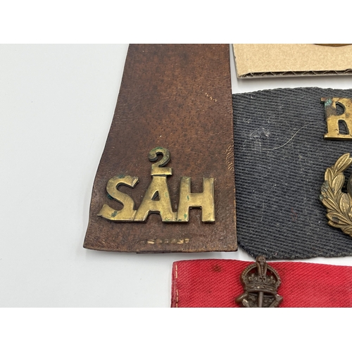 2162 - A collection of military badges and shoulder titles to include Royal Scots, Royal Marines etc.