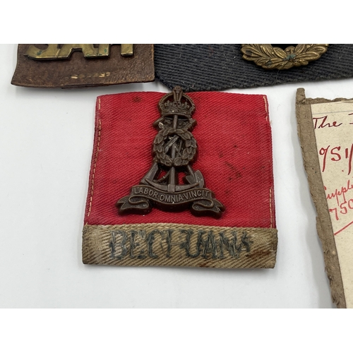 2162 - A collection of military badges and shoulder titles to include Royal Scots, Royal Marines etc.