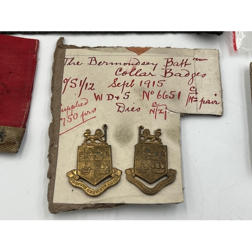 2162 - A collection of military badges and shoulder titles to include Royal Scots, Royal Marines etc.