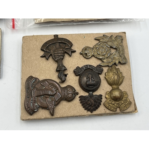 2162 - A collection of military badges and shoulder titles to include Royal Scots, Royal Marines etc.