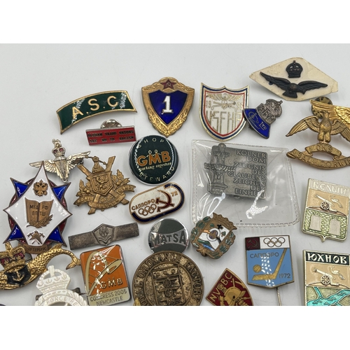 2167 - A collection of badges to include Royal Air Force mother of pearl, USSR 1972 Olympics enamel etc.