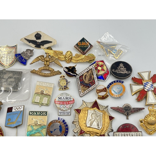 2167 - A collection of badges to include Royal Air Force mother of pearl, USSR 1972 Olympics enamel etc.