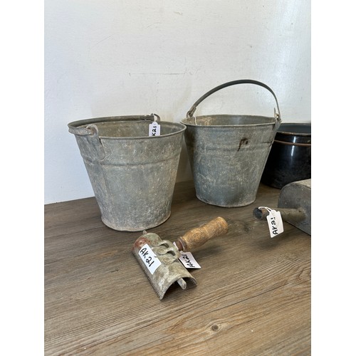 413 - A collection of metalware to include galvanized buckets, galvanized feed scoops, black and white ena... 