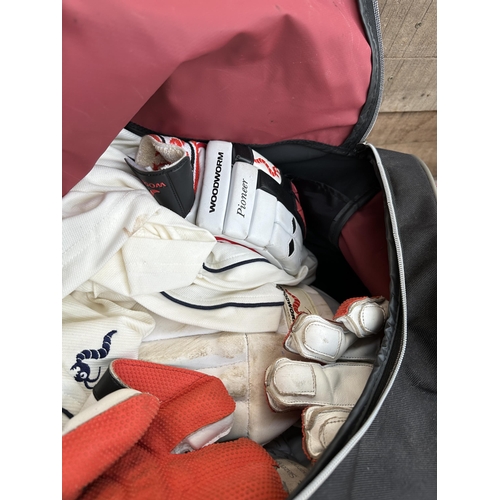 1018 - A bag containing child’s cricket equipment to include Woodworm bat, Slazenger pads, Woodworm gloves ... 