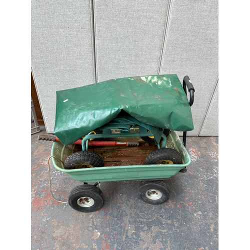 1026A - Four items, one plastic pull along garden trolley, one rolling metal garden seat and two tarpauline ... 