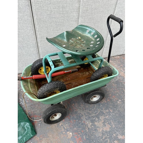 1026A - Four items, one plastic pull along garden trolley, one rolling metal garden seat and two tarpauline ... 