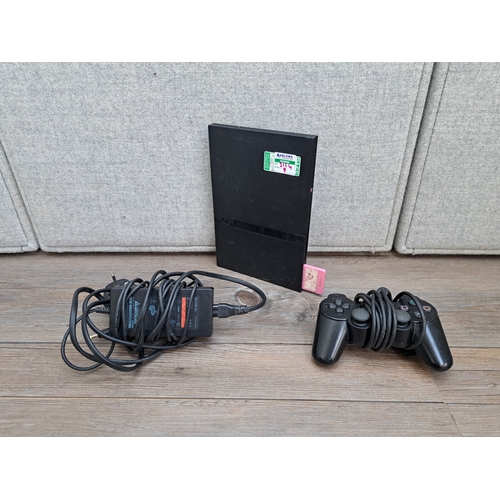 657 - A Sony PlayStation 2 SCPH-70003 slim console with DualShock 2 controller, AC adapter and a large col... 