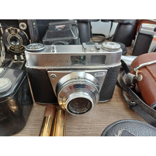 715 - A collection of vintage cameras, binoculars and accessories to include Kodak Baby Brownie, Prinz 10x... 